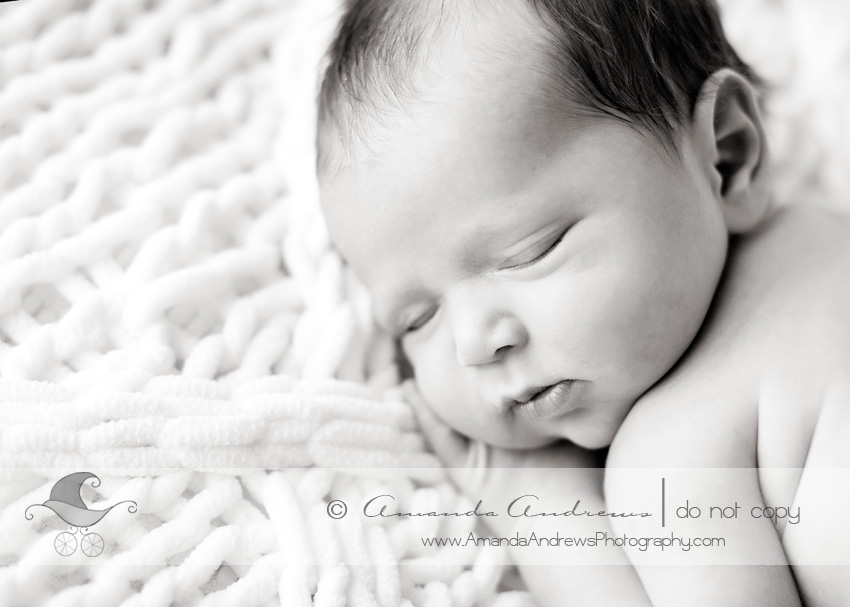  close up photograph of newborn baby on white blanket