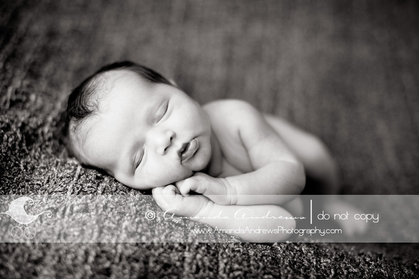 black and white picture of newborn baby on brown blanket