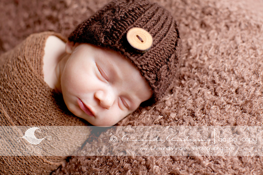 picture of baby boy on brown blanket with brown button hat