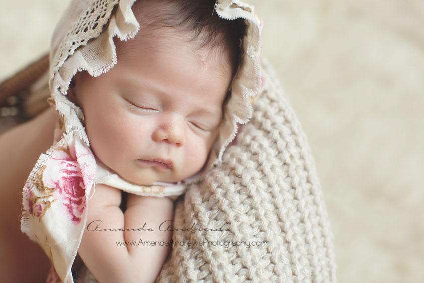 newborn sleeping with flower bonnet on