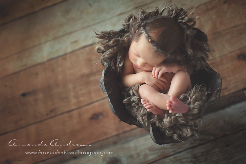 sleeping newborn in wood bowl