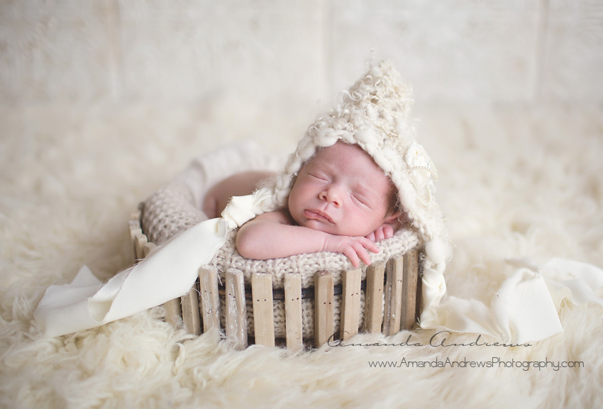 sleeping newborn in white basket