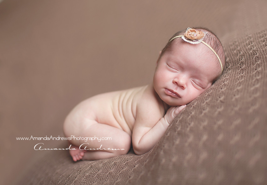 baby girl asleep on brown blanket