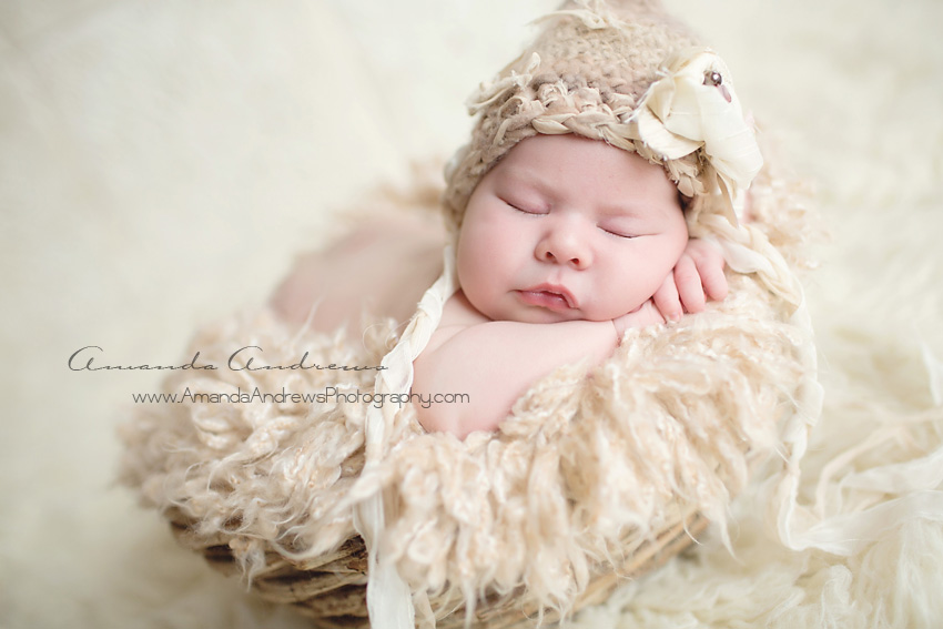 infant sleeping in basket with hat