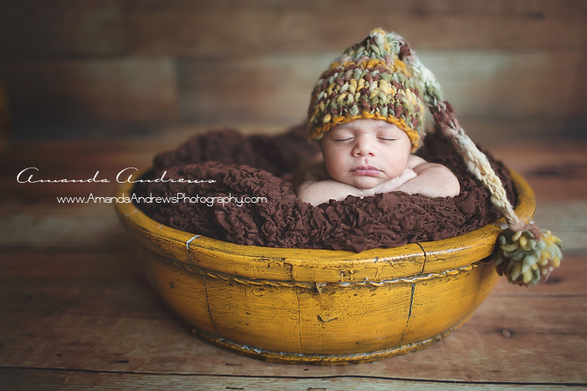 picture of newborn sleepign in yellow bucket boise idaho