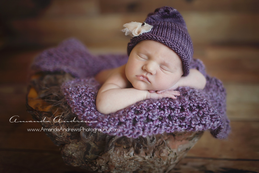 newborn sleeping in wooden bowl