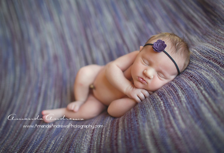 infant asleep on purple blanket
