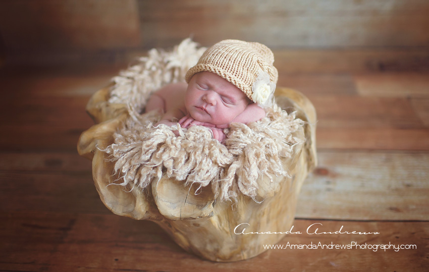 infant sleeping in wooden bowl