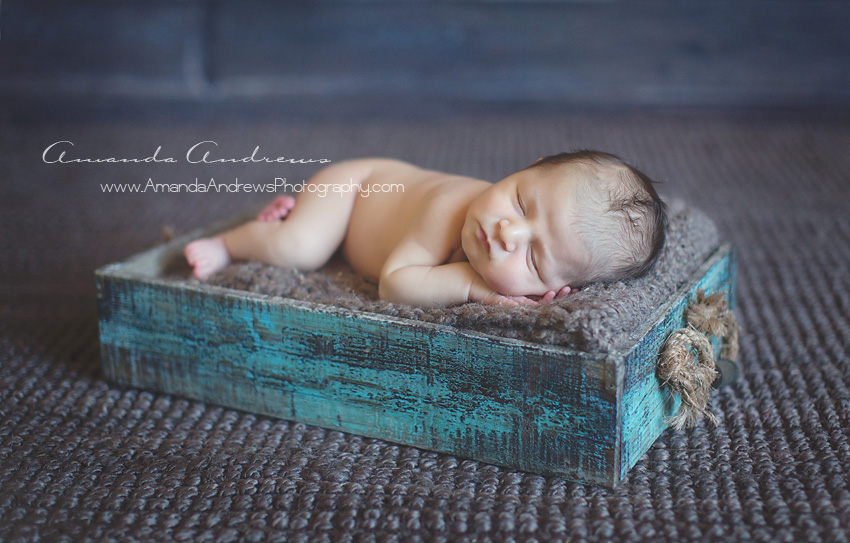 newborn sleeping in blue box
