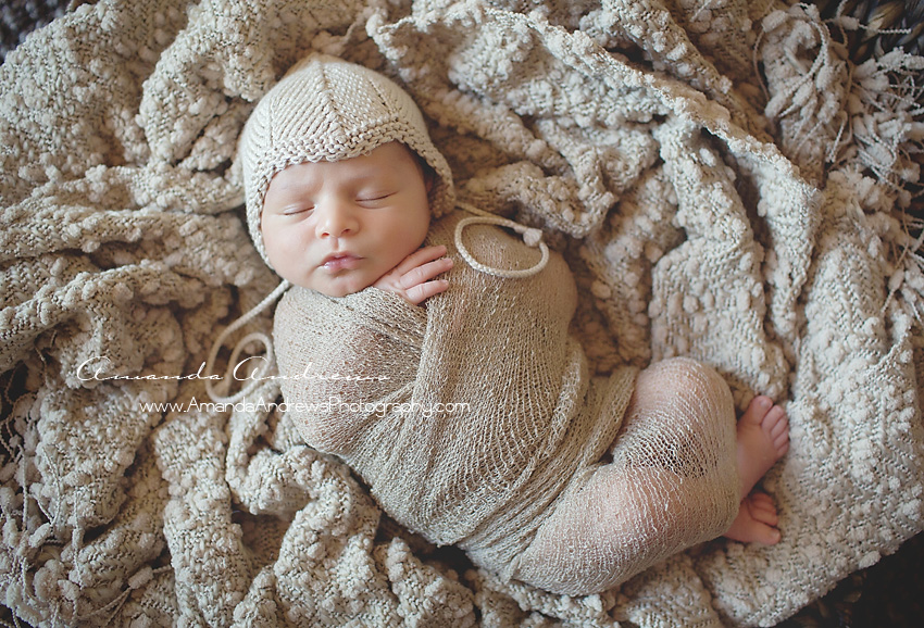 wrapped infant with hat on